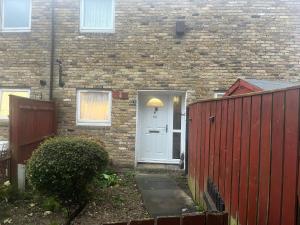 a house with a white door and a red fence at Queenomega’s home stay in London