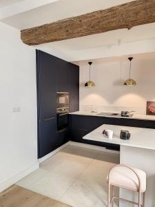 a kitchen with black cabinets and a white counter top at Appartement de charme avec cour in Avignon