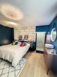a bedroom with a large bed and a blue wall at Appartement de charme avec cour in Avignon
