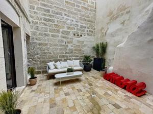 a living room with a couch and a brick wall at Appartement de charme avec cour in Avignon