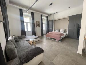 - un salon avec un canapé et un lit dans l'établissement Plaza Teatro & Piazzale Teatro, à Rijeka