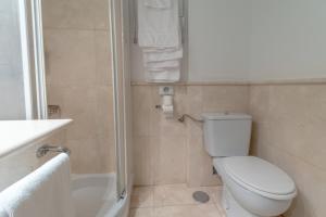 a bathroom with a toilet and a shower and a sink at Hotel Náyade in Los Ángeles de San Rafael