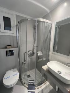 a bathroom with a shower and a toilet and a sink at Sailor's Nautical Concept in Spetses