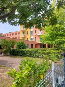 a building with a fence in front of a garden at Corallo Cavallino in Cavallino-Treporti