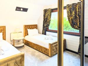 a bedroom with two beds and a window at Lugh 9 - Hot Tub-Perth-Pets-Luxury-Hunting Tower in Perth