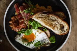 um prato de comida de pequeno-almoço com ovos, bacon e feijão em Sundvolden Hotel em Sundvollen