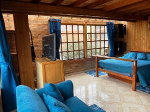 a living room with a couch and a tv at El Peregrino in Cota