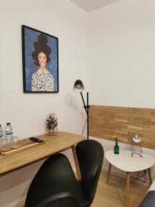 a room with a desk and a painting of a woman at Casa das Portas in Azinhaga