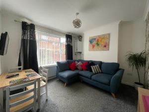 uma sala de estar com um sofá azul e uma mesa em Fionn House Darlington em Darlington