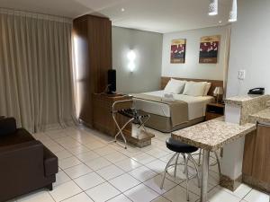 um quarto de hotel com uma cama, uma mesa e cadeiras em Sun Square Suítes Hotel By Lual em Goiânia