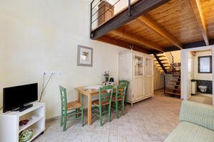 ein Wohnzimmer mit einem Tisch, Stühlen und einem TV in der Unterkunft Pesco Agriturismo La Ferla in Toirano