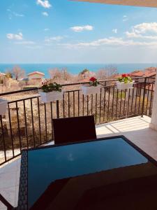 een laptop op een balkon met uitzicht op de oceaan bij Panorama Pearl in Balchik