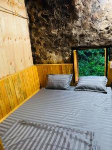 a bed in a room with a window at Nhà Cổ Bản Giốc Homestay - Làng đá Khuổi Ky in Bản Piên