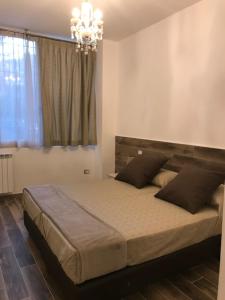 um quarto com uma cama grande e um lustre em MagloInnFiera em Bolonha