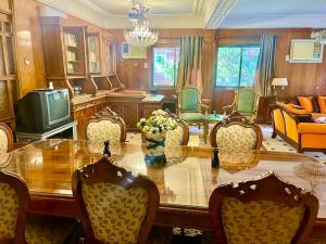 a dining room with a table and chairs and a tv at 4-Brs Historical Apt in Maadi 5-Min to Nile in Cairo