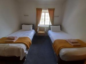 2 camas en una habitación con ventana en Burnthwaite Farm B&B 