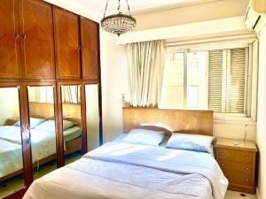a bedroom with two beds and a chandelier at 4-Brs Historical Apt in Maadi 5-Min to Nile in Cairo
