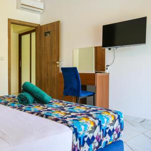 - une chambre avec un lit, un bureau et une télévision dans l'établissement Hotel Jnane riad, à Marrakech