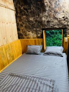 a bed in a room with a window at Nhà Cổ Bản Giốc Homestay - Làng đá Khuổi Ky in Bản Piên