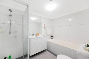 a white bathroom with a shower and a toilet at Sky-view 2B2B1G in Hurstville -1 min to Westfield in Sydney +13 photos