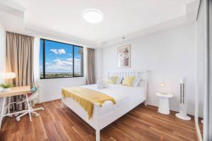 a white bedroom with a bed and a desk and a window at Sky-view 2B2B1G in Hurstville -1 min to Westfield in Sydney