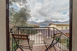 d'un balcon avec deux chaises et une vue sur les montagnes. dans l'établissement Garda Doma, à Brenzone