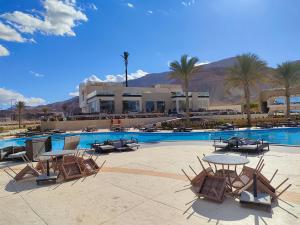 a resort with a pool with chairs and tables at Eastern El-Galala Aquapark Ain Sokhna in Ain Sokhna