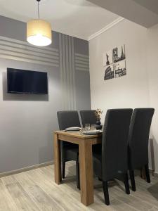 a dining room with a wooden table and chairs at DT Luxury Apartment in Nea Peramos +28 photos