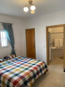 a bedroom with a bed with a checkered blanket at Casa Encina in Torremolinos