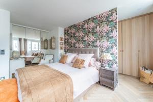 1 dormitorio con 1 cama grande y pared de flores en Splendide Appartement Cosy, en Charenton-le-Pont