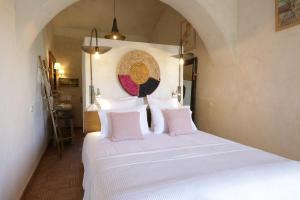 a bedroom with a white bed with pink pillows at Quinta Baltazar Casa particular in Vila Nova de Cacela