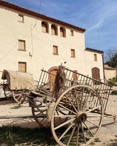 a horse drawn carriage parked in front of a building at Masia Ca la Jepa in Juncosa