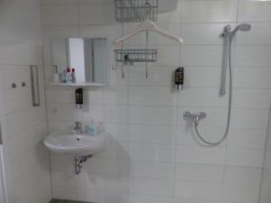 a white bathroom with a sink and a shower at Ferienwohnung in 09548 Seiffen bis maximal 18 Personen in Kurort Seiffen