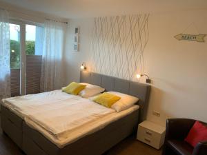 um quarto com uma cama com duas almofadas amarelas em Yachthafenresidenz-Wohnung-8106-9412 em Kühlungsborn