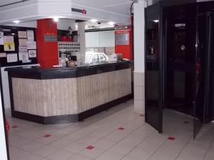 a restaurant with a counter in a building at Hotel Rota do Pantanal in Presidente Prudente