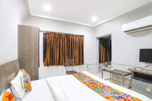 ein Hotelzimmer mit einem Bett und einem TV in der Unterkunft FabHotel Sun Om in Raipur
