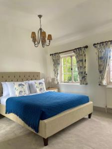 um quarto com uma cama azul e uma janela em Denham Mount em Buckinghamshire