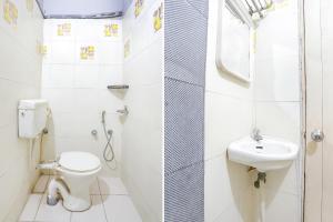 een witte badkamer met een toilet en een wastafel bij FabHotel Sun Om in Raipur