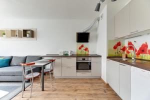 kuchnia i salon z kanapą i stołem w obiekcie Spektrum by Grand Apartments w Gdańsku