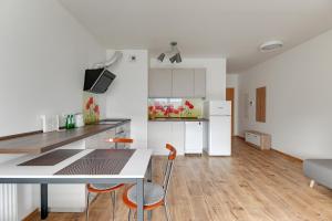 cocina y sala de estar con mesa y sillas en Spektrum by Grand Apartments en Gdansk