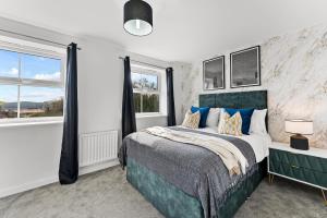 a bedroom with a large bed and windows at Captivating 4 bed House - Parking - Sleeps 14 in Bristol