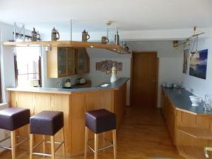 a kitchen with a counter and stools in it at Große Ferienwohnung in 09548 Seiffen in Kurort Seiffen