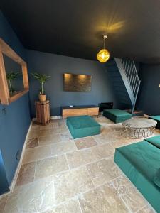 a living room with a couch and a staircase at L'ATELIER DU VIEUX BOIS Spa in Bayeux