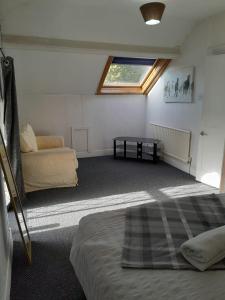 a room with a bed and a couch and a window at Singleton Short Stay Basic Loft Rooms in Swansea