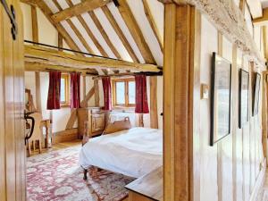 ein Schlafzimmer mit einem Bett in einem Zimmer in der Unterkunft Walnut Barn - Horsham in Horsham