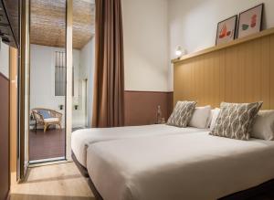 a hotel room with a large bed and a balcony at BYPILLOW Ramblas in Barcelona