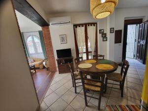 a dining room and living room with a table and chairs at Amici di Calabria in Scalea