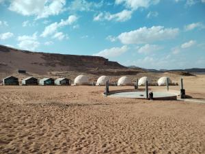 Un desierto con un grupo de tiendas en la arena en Rum Grand Tours Camp, en Disah