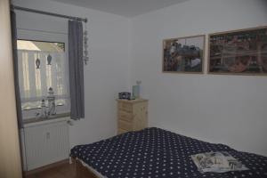 a bedroom with a bed and a window at Ferienanlage-Reriker-Strasse-EG-links-9388 in Kühlungsborn