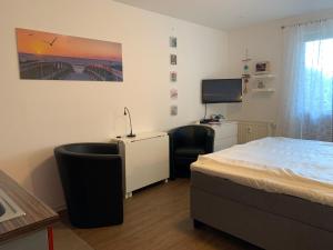 a bedroom with a bed and a desk and a tv at Yachthafenresidenz-Wohnung-8106-9412 in Kühlungsborn